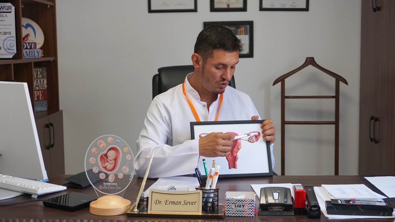 Le Dr Erman Sever expliquant un traitement à l'aide d'une planche anatomique